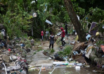 Residentes intentan rescatar sus pertenencias luego del desborde del río Magua, al noroeste de Santo Domingo, República Dominicana, el fin de semana