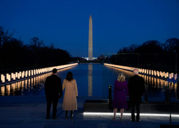 With the Washington Monument in the background, President-elect Joe Biden with his wife Jill Biden and Vice President-elect Kamala Harris with her husband Doug Emhoff listen as Yolanda Adams sings "Hallelujah" during a COVID-19 memorial, with lights placed around the Lincoln Memorial Reflecting Pool, Tuesday, Jan. 19, 2021, in Washington. (AP Photo/Evan Vucci)