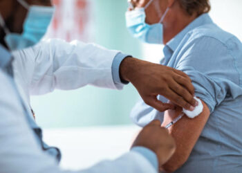 Close up of a mature man taking a vaccine in his doctors office