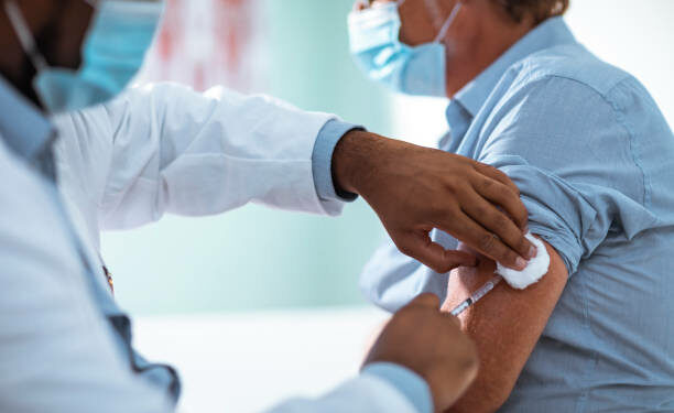 Close up of a mature man taking a vaccine in his doctors office