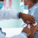 Close up of a mature man taking a vaccine in his doctors office