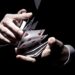 A magician shuffling the cards in a cool way under the spotlight