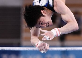 Japan's Kohei Uchimura competes in the horizontal bars event of the artistic gymnastics men's qualification during the Tokyo 2020 Olympic Games at the Ariake Gymnastics Centre in Tokyo on July 24, 2021. (Photo by Loic VENANCE / AFP)