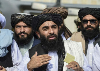 Taliban spokesman Zabihullah Mujahid (C) addresses a media conference at the airport in Kabul on August 31, 2021. - The Taliban joyously fired guns into the air and offered words of reconciliation on August 31, as they celebrated defeating the United States and returning to power after two decades of war that devastated Afghanistan. (Photo by WAKIL KOHSAR / AFP)