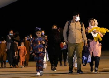 Afghan people who were transported from Islamabad, walk after disembarking a plane, at the Torrejon military base in Spain on Monday, Oct. 11, 2021. (AP Photo/Manu Fernandez)