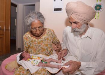 Indian parents Mohinder Singh Gill (L), 79, and Daljinder Kaur, 70, hold their newborn baby boy Arman at their home in Amritsar on May 11, 2016. An Indian woman who gave birth at the age of 70 said May 10 she was not too old to become a first-time mother, adding that her life was now complete. Daljinder Kaur gave birth last month to a boy following two years of IVF treatment at a fertility clinic in the northern state of Haryana with her 79-year-old husband.
 / AFP / NARINDER NANU