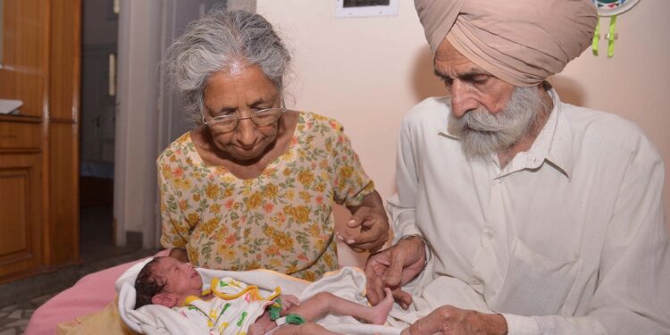 Indian parents Mohinder Singh Gill (L), 79, and Daljinder Kaur, 70, hold their newborn baby boy Arman at their home in Amritsar on May 11, 2016. An Indian woman who gave birth at the age of 70 said May 10 she was not too old to become a first-time mother, adding that her life was now complete. Daljinder Kaur gave birth last month to a boy following two years of IVF treatment at a fertility clinic in the northern state of Haryana with her 79-year-old husband. / AFP / NARINDER NANU