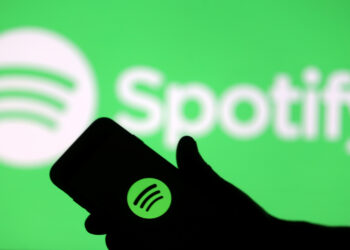 FILE PHOTO: A smartphone is seen in front of a screen projection of Spotify logo, in this picture illustration taken April 1, 2018. REUTERS/Dado Ruvic/Illustration/File Photo  GLOBAL BUSINESS WEEK AHEAD