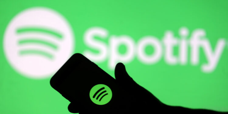 FILE PHOTO: A smartphone is seen in front of a screen projection of Spotify logo, in this picture illustration taken April 1, 2018. REUTERS/Dado Ruvic/Illustration/File Photo  GLOBAL BUSINESS WEEK AHEAD