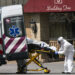 Empleados médicos suben una persona fallecida a una ambulancia