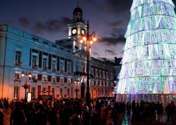 People walk under Christmas lights at Puerta del Sol square, amid the coronavirus disease (COVID-19) pandemic, in Madrid, Spain, December 8, 2021. REUTERS/Susana Vera