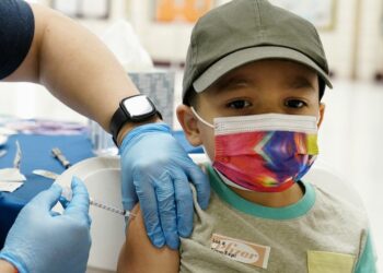 Oliver Estrada, 5, receives the first dose of the Pfizer COVID-19 vaccine at an Adelante Healthcare community vaccine clinic at Joseph Zito Elementary School, Saturday, Nov. 6, 2021, in Phoenix. This was the first time children aged 5 to 11 across the United States had the opportunity to get immunized against COVID-19. (AP Photo/Ross D. Franklin)