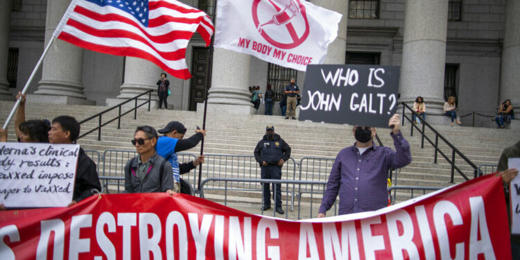 Police watch as people and teachers hold a protest against COVID vaccine mandates outside the Manhattan Federal Court Tuesday, Oct. 12, 2021, in New York. (AP Photo/Eduardo Munoz Alvarez)