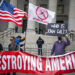 Police watch as people and teachers hold a protest against COVID vaccine mandates outside the Manhattan Federal Court Tuesday, Oct. 12, 2021, in New York. (AP Photo/Eduardo Munoz Alvarez)