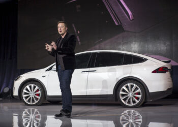 Elon Musk, chairman and chief executive officer of Tesla Motors Inc., unveils the Model X sport utility vehicle (SUV) during an event in Fremont, California, U.S., on Tuesday, Sept. 29, 2015. Musk handed over the first six Model X SUVs to owners in California Tuesday night, as Tesla reached a milestone of having two all-electric vehicles in production at the same time. Photographer: David Paul Morris/Bloomberg *** Local Caption *** Elon Musk