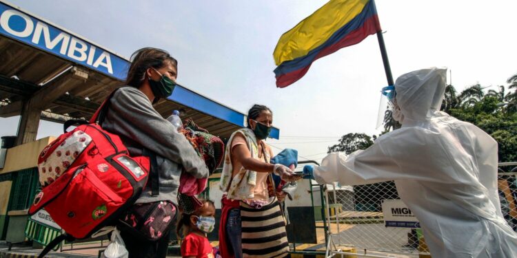 Staffers from Colombia's Secretary of Health check Venezuelans while leaving Colombia and returning to their country, as a preventive measure against the spread of the COVID-19 coronavirus, at the Simon Bolivar International Bridge, in Cucuta, Colombia-Venezuela border, on April 28, 2020. (Photo by Schneyder MENDOZA / AFP) (Photo by SCHNEYDER MENDOZA/AFP via Getty Images)