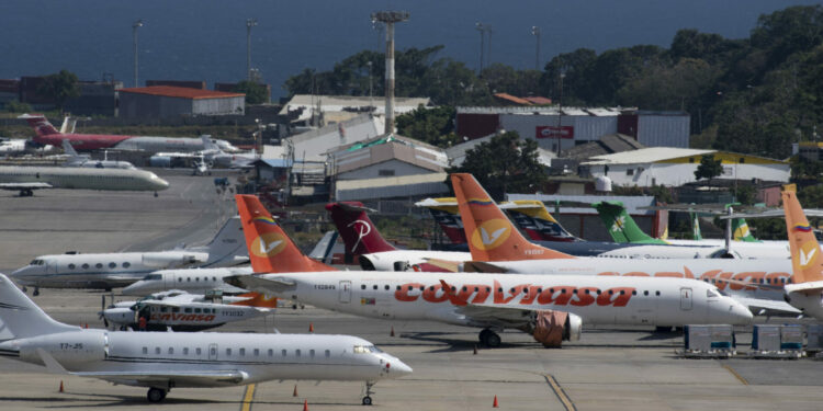 Commercial planes of different airlines and private jets sit on the tarmac at Simon Bolivar International Airport, in Maiquetia, Vargas State, Venezuela, on December 15, 2020. - Air workers in Venezuela are facing an unemployment crisis due to the novel coronavirus, COVID-19, pandemic. The country's private airlines were grounded for months due to the pandemic but when flights were allowed to resume, the government closed most of the routes covered, leaving only Turkey, Bolivia and Mexico open. (Photo by Yuri CORTEZ / AFP)
