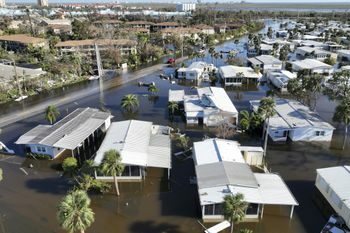 Rescue personnel search a flooded trailer park after Hurricane Ian passed by the area Thursday, Sept. 29, 2022, in Fort Myers, Fla. (AP Photo/Steve Helber)