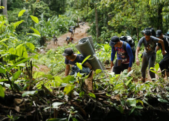 ACOMPAÑA CRÓNICA: CRISIS MIGRATORIA***AME3342. TAPÓN DEL DARIÉN (COLOMBIA), 10/10/2022.- Migrantes venezolanos suben una montaña con la intención de llegar a Panamá, el 8 de octubre de 2022 en el Tapón del Darién (Colombia). Cuando José Juan le dijo a Steven que quería ir a EE.UU. por el Darién, su hijo de 7 años le dijo que eso era peligroso, que era mejor hacerlo en avión, pero aún así ahora lidera enérgico el grupo de migrantes que comienza su travesía por esta inhóspita selva que separa a Colombia de Panamá. Como ellos, más de 150.000 personas -el 60 % de ellos venezolanos- han decidido cruzar en lo que va de año por uno de los pasos migratorios más peligrosos del mundo, una travesía que puede durar la semana por una selva montañosa donde no hay ley. EFE/Mauricio Dueñas Castañeda