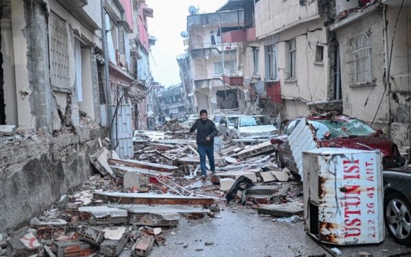 A man runs along a street strewn with debris, in Hatay,  the day after a 7.8-magnitude earthquake struck the country's southeast on February 7, 2023. - Rescuers in Turkey and Syria braved frigid weather, aftershocks and collapsing buildings, as they dug for survivors buried by an earthquake that killed more than 5,000 people. Up to 23 million people could be affected by the massive earthquake that has killed thousands in Turkey and Syria, the WHO warned on Tuesday, promising long-term assistance. (Photo by BULENT KILIC / AFP)