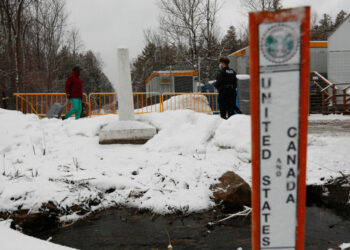 Royal Canadian Mounted Police officers greet refugees as they arrive at the Roxham Road border crossing in Champlain, New York, on March 25, 2023. - The Roxham Road crossing closed at midnight March 24, as Canadian and US media reported that Canada will be able to turn back illegal migrants at the crossing point on the frontier between New York state and Quebec. The reports said that Canada has agreed in return to take in some 15,000 asylum seekers from Latin America through legal channels, a move that will ease the pressure on the southern US border. Radio-Canada reported that the deal would take effect Saturday. (Photo by Lars Hagberg / AFP) (Photo by LARS HAGBERG/AFP via Getty Images)