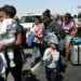 (FILES) Migrants of different nationalities are escorted by Peruvian police officers to a migration office in Tacna, in the Peru-Chile border on April 28, 2023. - Chile confirmed that a first repatriation flight will depart on May 7 for hundreds of Venezuelan migrants stranded on the border with Peru who have been seeking to return to their country of origin for weeks, Chilean Foreign Minister Alberto van Klaveren said on May 4. (Photo by ALDAIR MEJIA / AFP)