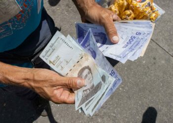 Un ciudadano fue registrado al sostener varios bolívares, en Caracas (Venezuela). EFE/Ronald Peña