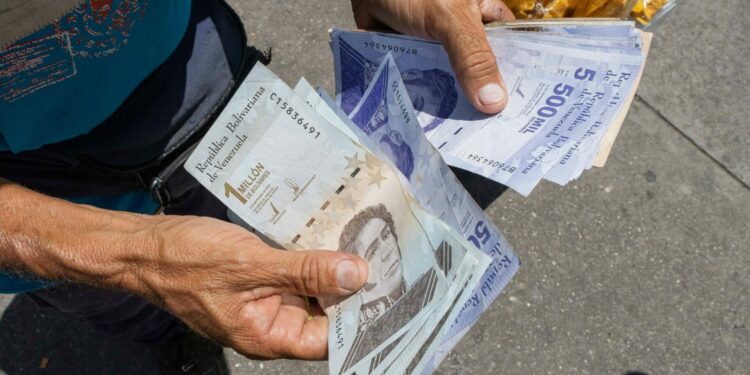 Un ciudadano fue registrado al sostener varios bolívares, en Caracas (Venezuela). EFE/Ronald Peña