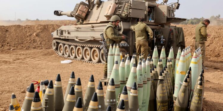 Artillery shells are lined up next to an armoured vehicle as Israeli soldiers take positions near the border with Gaza in southern Israel on October 9, 2023. Stunned by the unprecedented assault on its territory, a grieving Israel has counted over 700 dead and launched a withering barrage of strikes on Gaza that have raised the death toll there to 493 according to Palestinian officials. (Photo by JACK GUEZ / AFP)